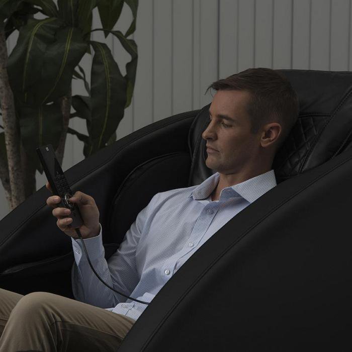 Inner Balance Wellness Ji Massage Chair IMR0047 in side view position with person holding a controller