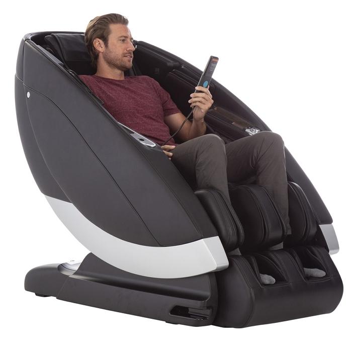 Human Touch Super Novo Massage Chair gray side view with person holding remote control